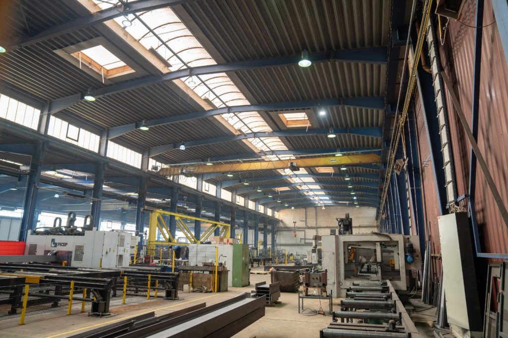 Blick in die Fertigungshalle mit Kranbahn und CNC-Anlagen